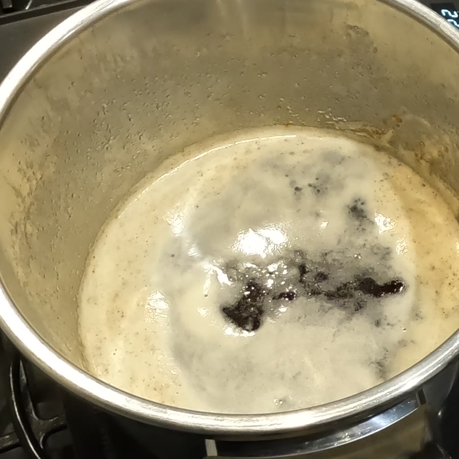 Browned milk solids gathered at the bottom of the pot under a thin foam.